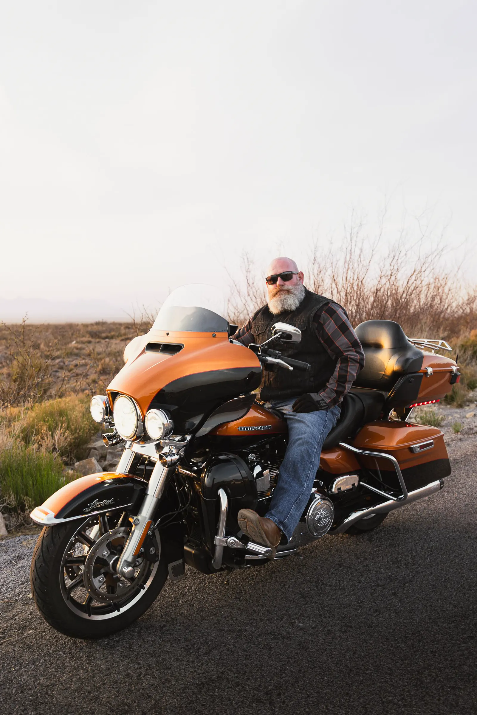 Rider on an orange touring motorcycle at sunset