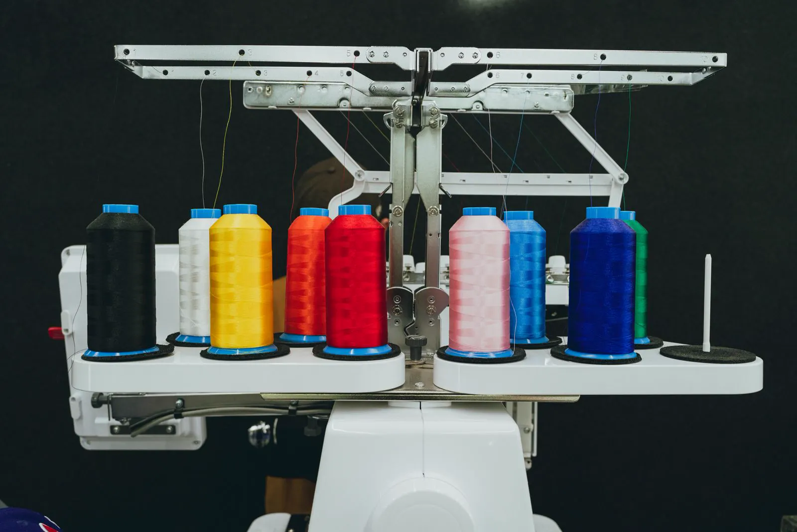 Spools of colored embroidery thread on a machine